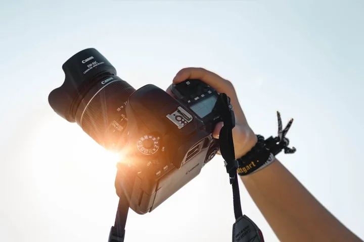 Obrazek przedstawia aparat fotograficzny wykadrowany pod słońce