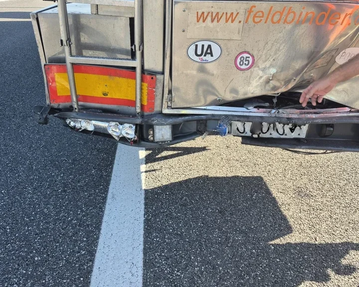 Uszkodzony tył srebrnej ciężarówki z widocznym zniszczonym zderzakiem i nadwoziem.