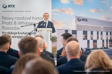 Mężczyzna w garniturze przemawia z mównicy podczas uroczystości otwarcia nowej fabryki RTX/Pratt & Whitney w Rzeszowie.
