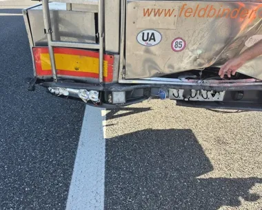 Uszkodzony tył srebrnej ciężarówki z widocznym zniszczonym zderzakiem i nadwoziem.