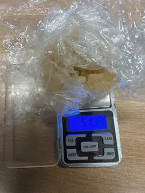 Kryształowa substancja w plastikowej folii na wadze elektronicznej.