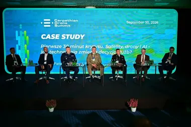 Panel siedmiu mężczyzn, w tym w mundurach wojskowych, siedzi na scenie podczas Carpathian Drone Summit podczas dyskusji case study o technologiach w kryzysie.