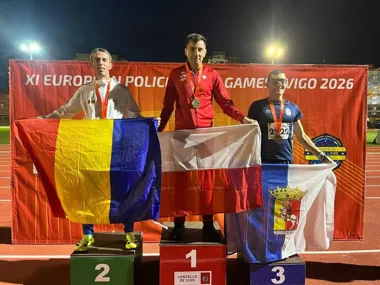 Trzech medalistów stoi na podium podczas XI European Police & Fire Games w Vigo w 2026 roku, trzymając flagi swoich krajów.