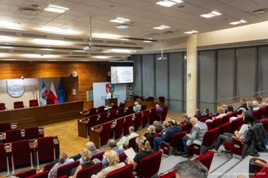 W sali konferencyjnej urzędu województwa podlaskiego odbywa się wykład o Camino de Santiago z udziałem publiczności.
